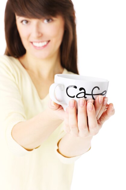 Photo a young woman holding a cup of coffee over white background