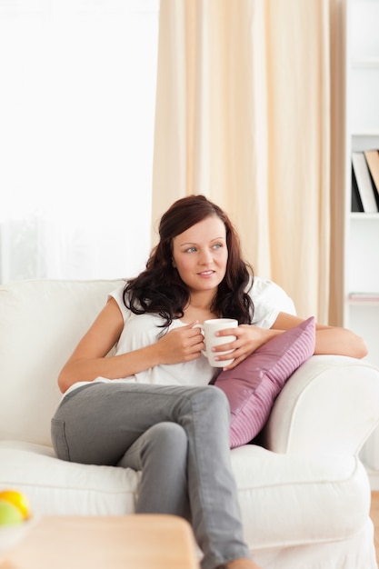 Young Woman holding a cup looking out the window