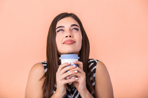 young woman holding cup of warm latte in hands cuddling