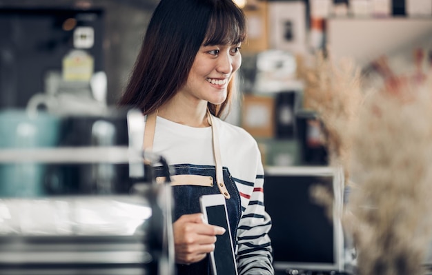 Young woman holding digital tablet while standing in cafe