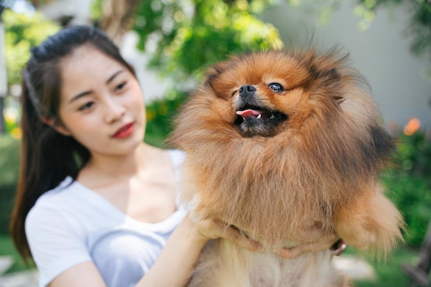 Photo young woman holding dog standing at park