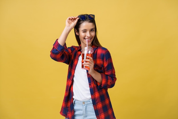 Young woman holding and drinking cold drink beverage in casual clothes pretty girl smiling happy laughing looking at camera