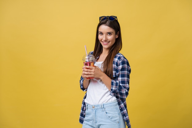 Young woman holding and drinking cold drink beverage in casual clothes. 