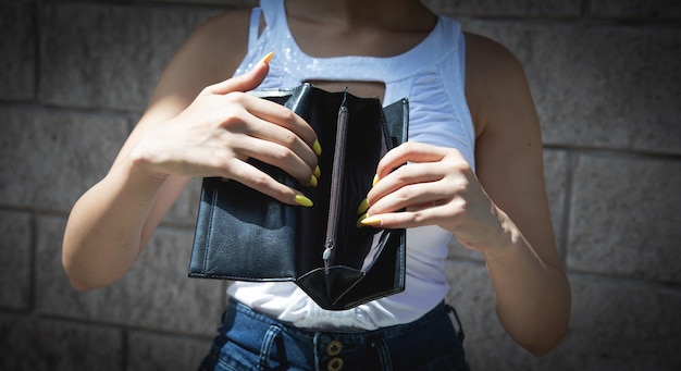 Young woman holding empty wallet No Money