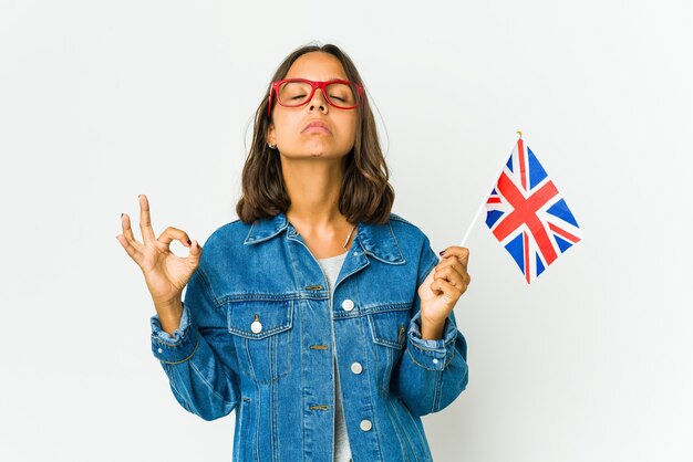 Young woman holding a english flag relaxes after hard working day, she is performing yoga