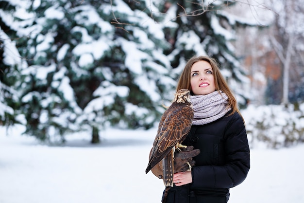 Young woman holding a falcon on arm