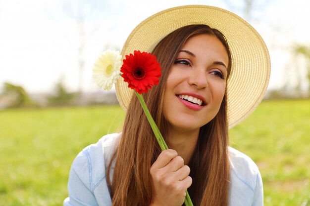 ガーベラの花を持つ若い女性