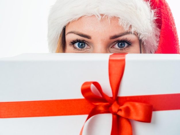 Young woman holding gift box behind her face