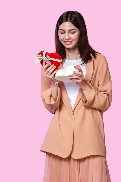 Young woman holding a gift in shape of heart