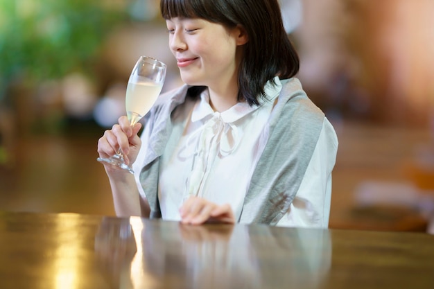 A young woman holding a glass of champagne in a warm atmosphere