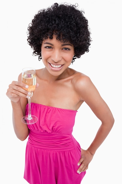 Young woman holding a glass of champagne with her hand on her hip