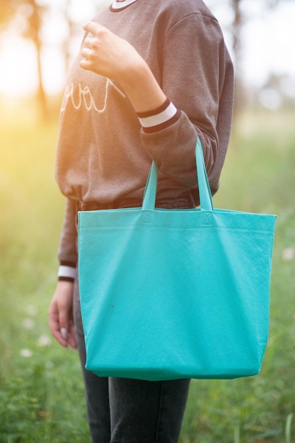 Young woman holding green tote bag