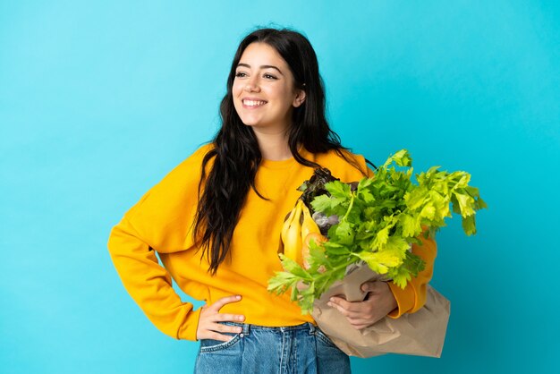 Young woman holding a grocery shopping bag isolated