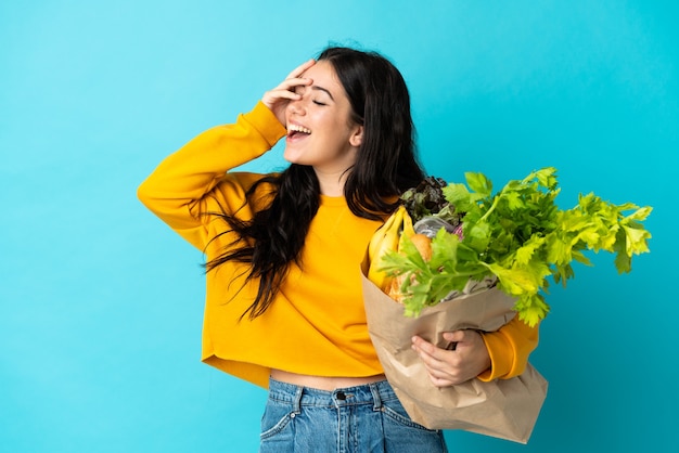 Young woman holding a grocery shopping bag isolated