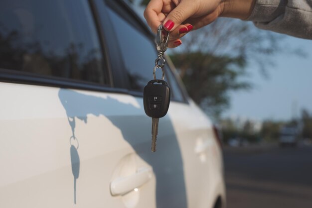 手車のキーを保持している若い女性。