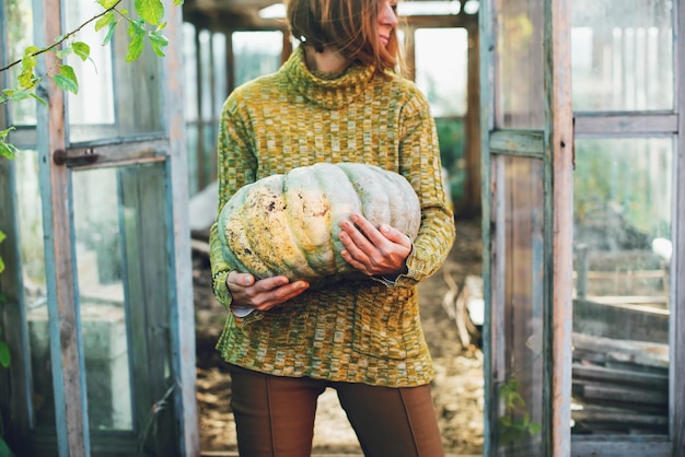 A young woman holding in her hands a pumpkin