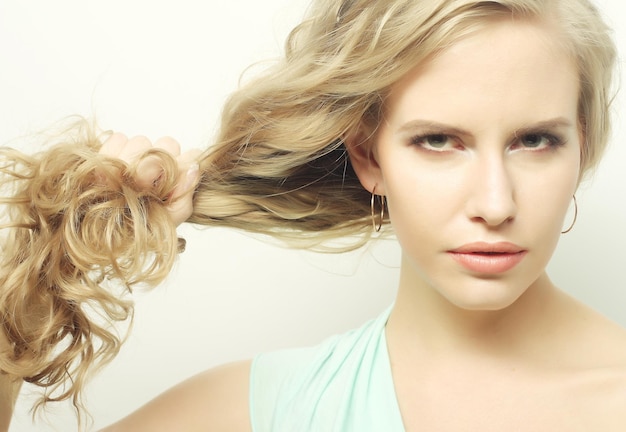 Young woman holding her long curly healthy hair