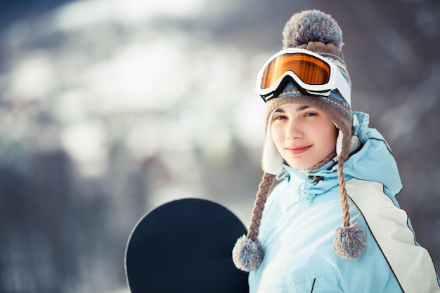 Young woman holding her snowboard