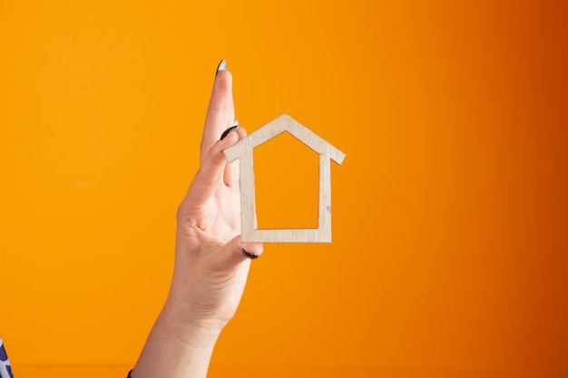 Young woman holding house in hands