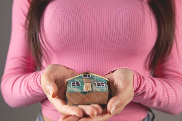 Young woman holding a house in her hands