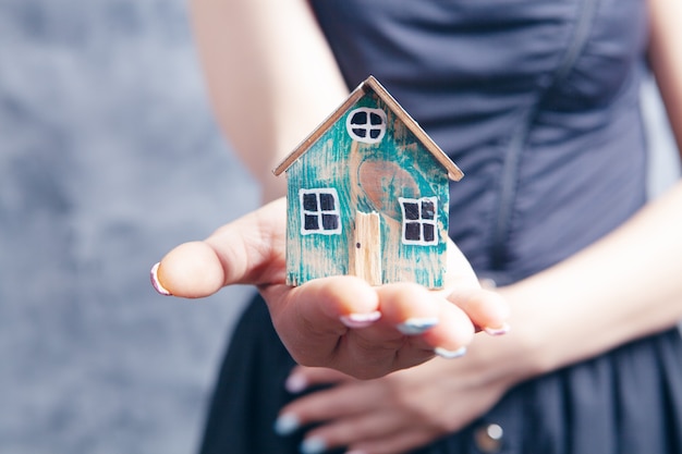 Young woman holding house  