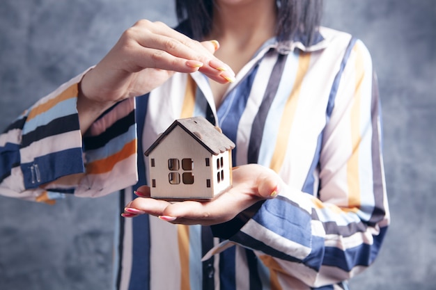 Young woman holding a house