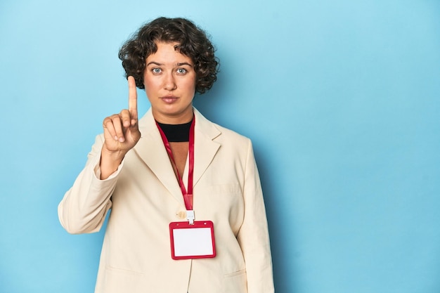 Young woman holding identification card for event showing number one with finger