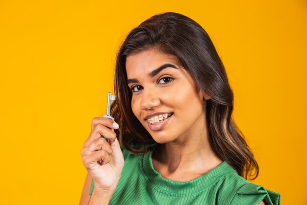 Young woman holding key to new house.