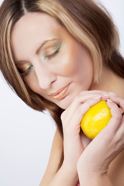 Photo young woman holding a lemon