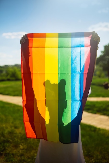 Young woman holding an LGBT pride flag in her hands