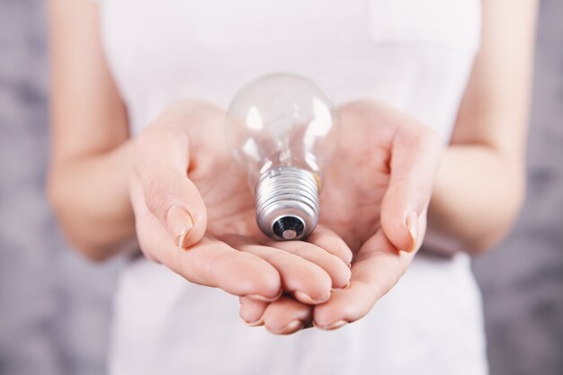 Young woman holding a light bulb