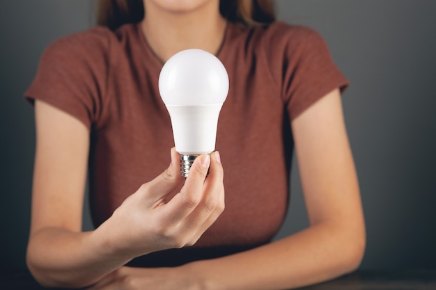 Young woman holding a light bulb