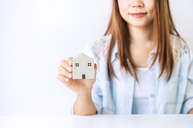 Young woman holding a little house