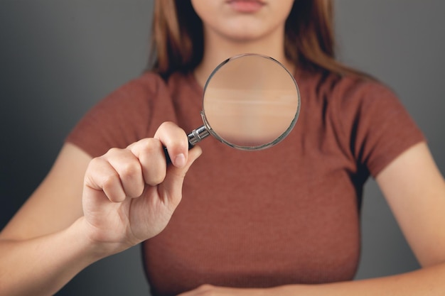 Young woman holding a magnifying glass