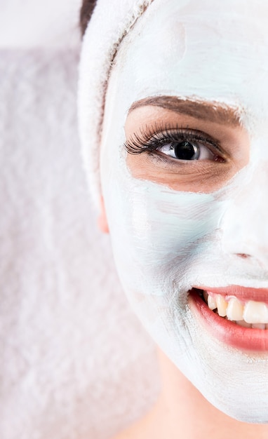 Maschera della tenuta della giovane donna sul fronte in un salone della stazione termale.