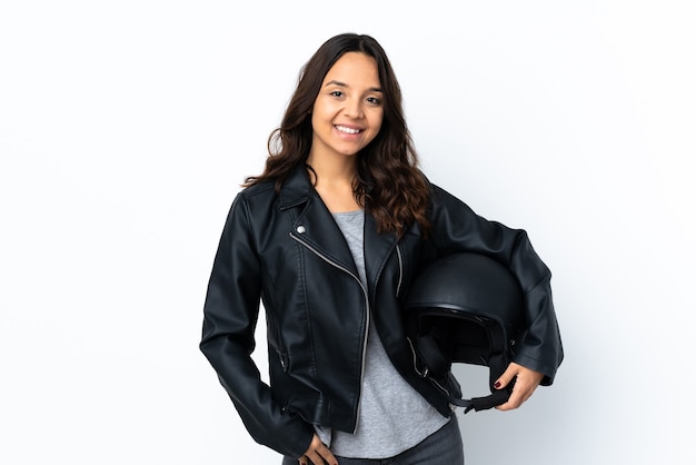 Young woman holding a motorcycle helmet over isolated white background laughing