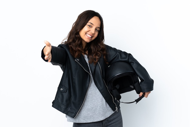 Young woman holding a motorcycle helmet over isolated white wall presenting and inviting to come with hand