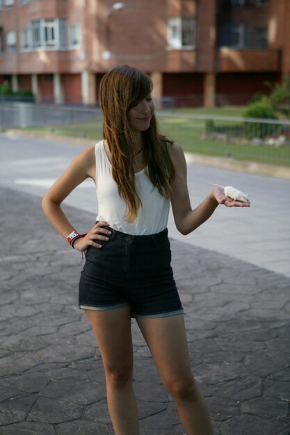 Young woman holding mouse on road