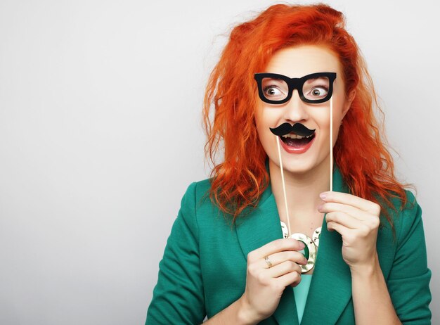 Young woman holding mustache