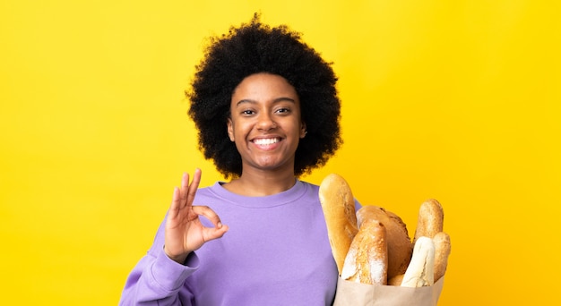 Молодая женщина, держащая бумажный пакет с хлебом