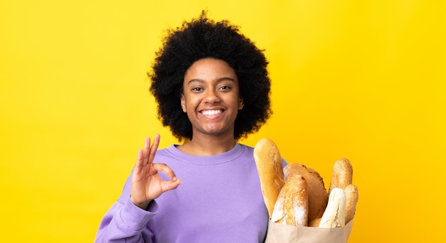 Young woman holding a paper bag with bread