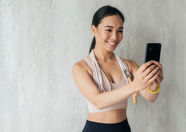 Giovane donna che tiene un telefono mentre vlog sullo sport