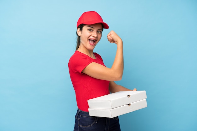 強いジェスチャーを作る分離のピンクの壁にピザを置く若い女性