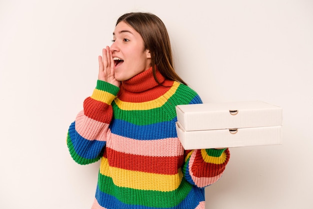 Young woman holding pizzas isolated on white background shouting and holding palm near opened mouth