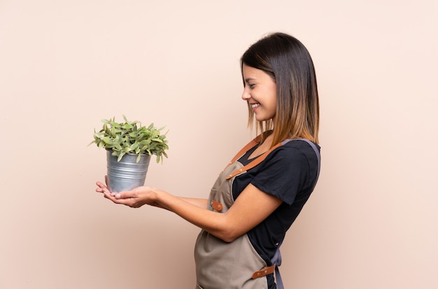 Young woman holding a plant with happy expression