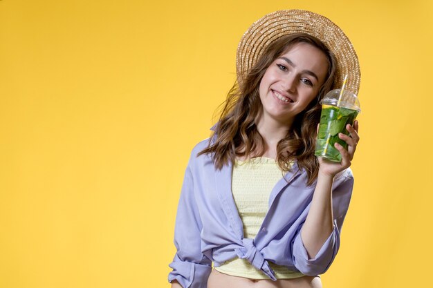 young woman holding plastic cup of lemonade