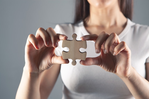 Foto giovane donna con in mano un pezzo di puzzle