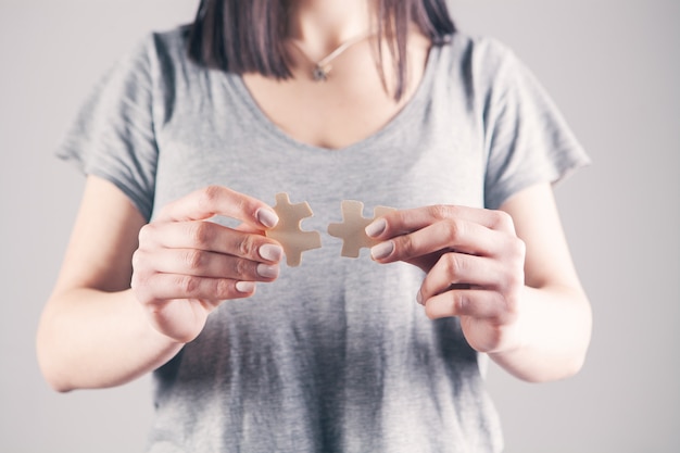 Young woman holding puzzle pieces