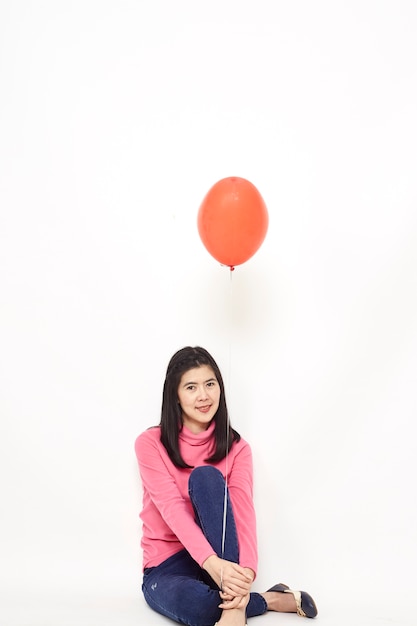 Young woman holding a red balloon