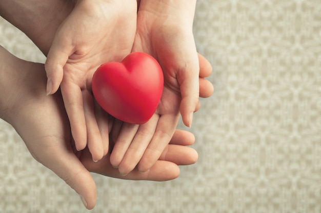 Young woman holding red heart, health insurance,